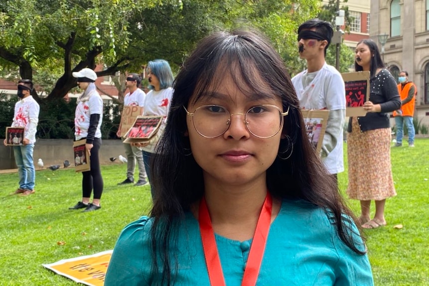 Student activist Mary Aung standing in front of protesters in Melbourne.