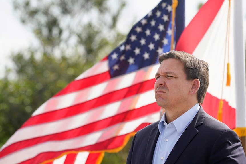 Ron DeSantis in front of an American flag.