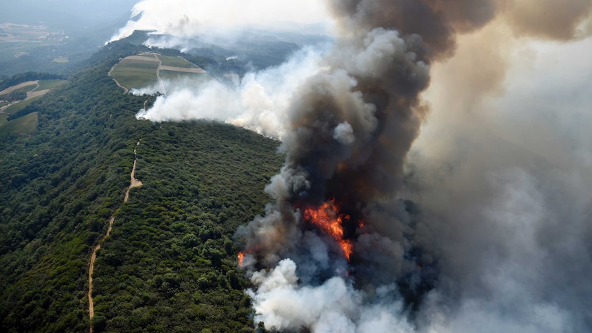 Smoke rises as a wildfire burns in the hills east of Napa.