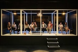 people sitting in glass pods watching theatre
