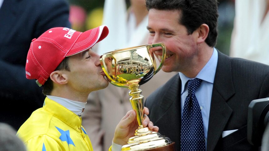 Victory is sweet: Mikel Delzangles celebrates his Melbourne Cup win with jockey Christophe Lemaire.