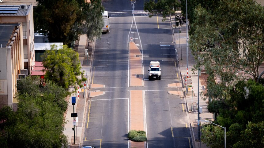 A police car drives down a street in Alice Springs