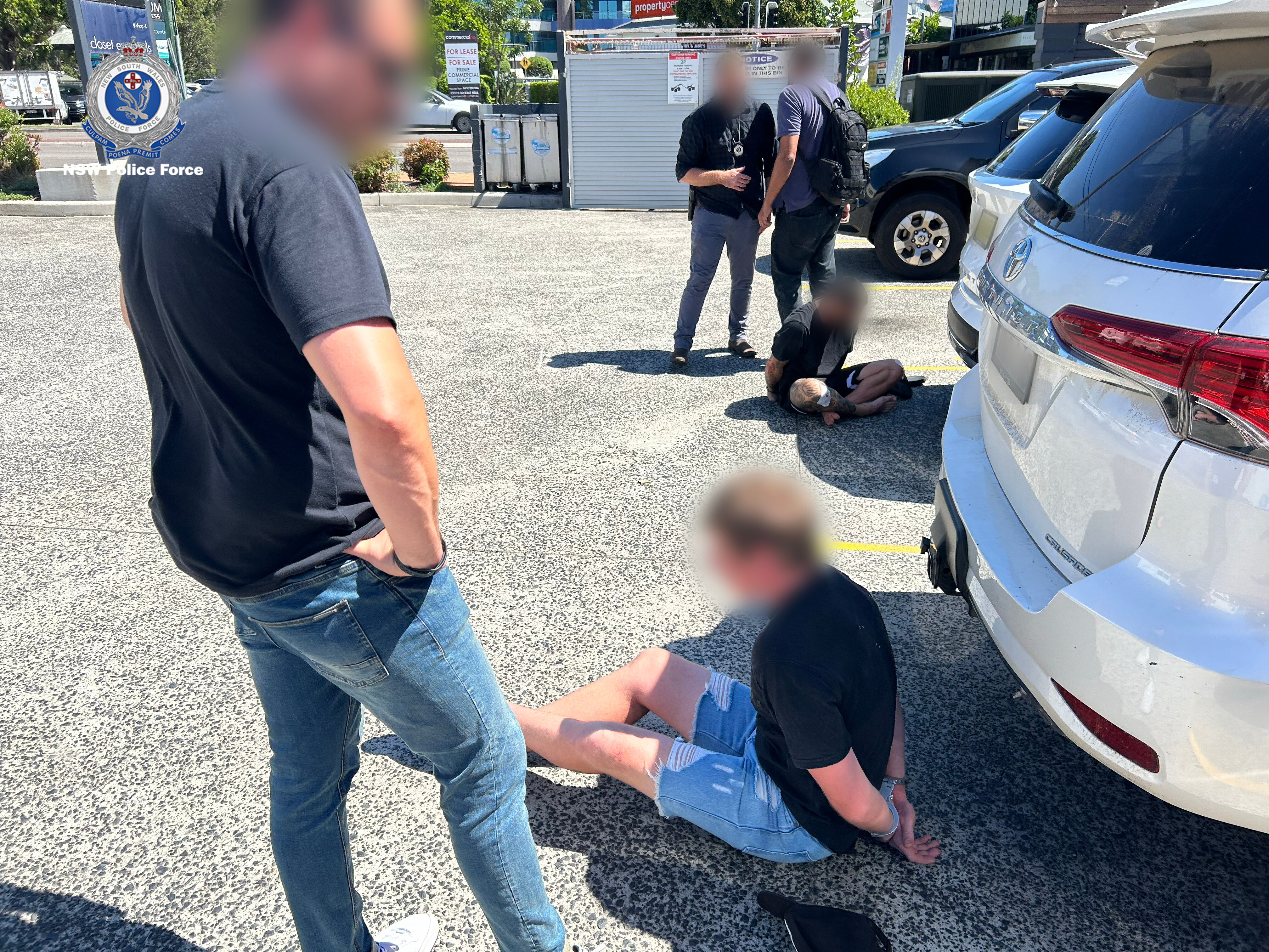 Two men on the ground being arrested.