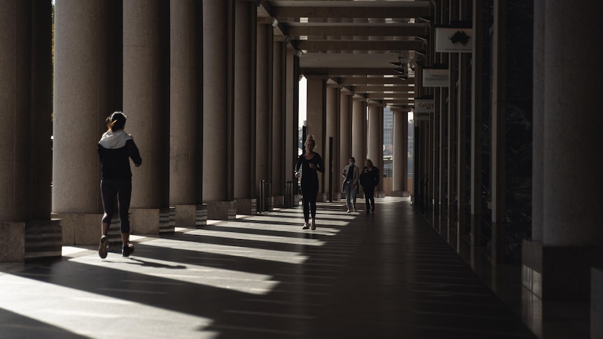 A woman walks down a covered walkway in Sydney
