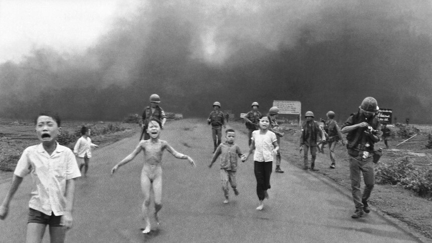 A black and white photograph of screaming children running.