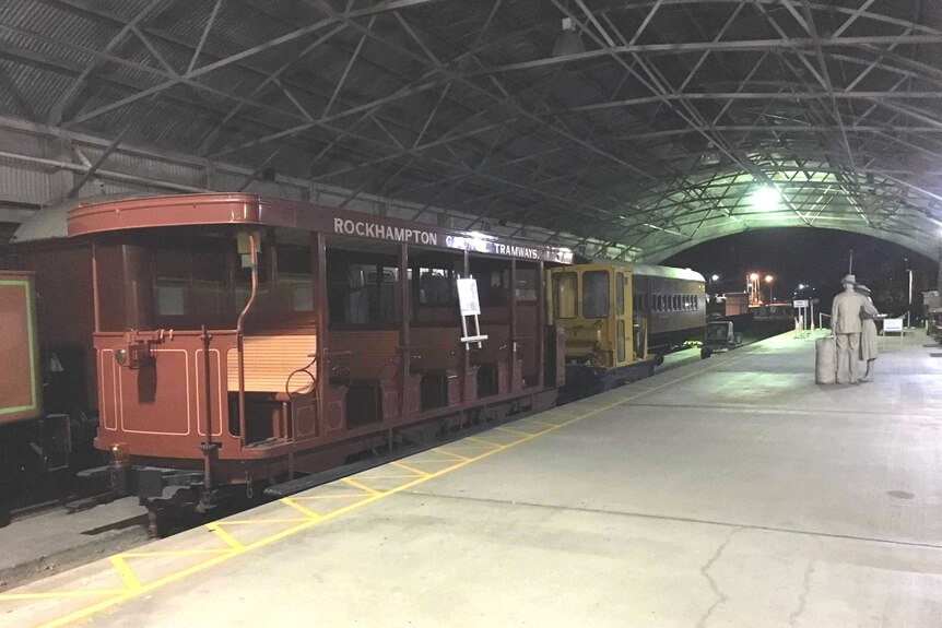 A tram stands at the platform at the deserted Archer Park Rail Museum at night