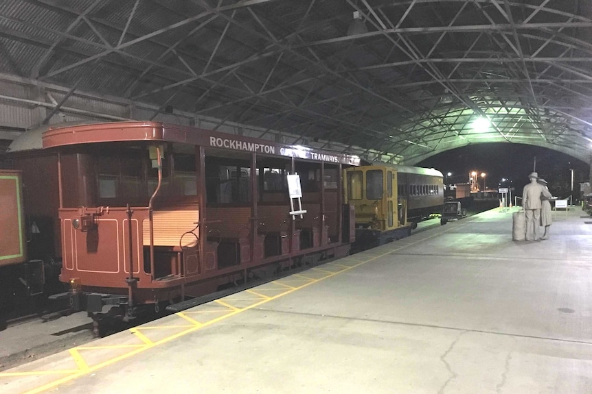A tram stands at the platform at the deserted Archer Park Rail Museum at night