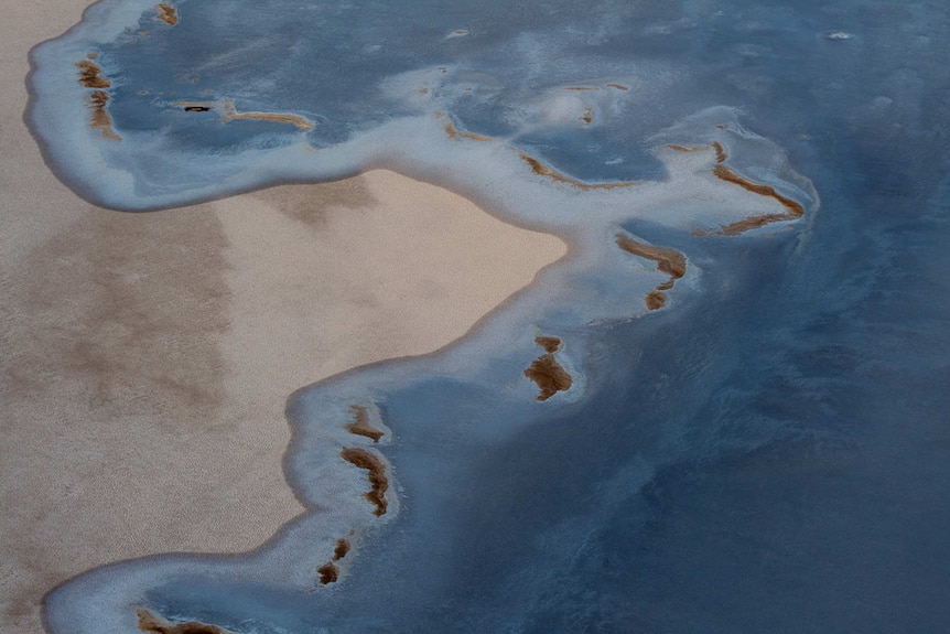 Blue water mixes with salt on Lake Eyre.