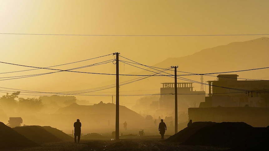 smoky yellow sky over afghanistan with some people visible through the haze