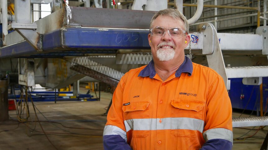 Rockhampton businessman Jack Trenaman wears orange high vis shirt and smiles at the camera in May 2022.