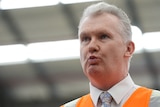 Tony Burke speaks while wearing a high-visibility vest.