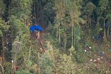 Rescue workers erect tarpaulins the site where an Airlines PNG Twin Otter aircraft crashed