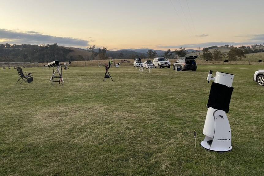 Telescopes set up on a field around sunset time in Buchan