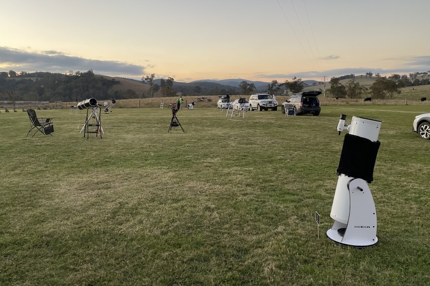 Telescopes set up on a field around sunset time in Buchan