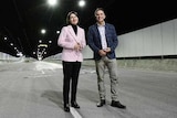 Gladys Berejiklian in a pink jacket in a motorway tunnel with Andrew Constance