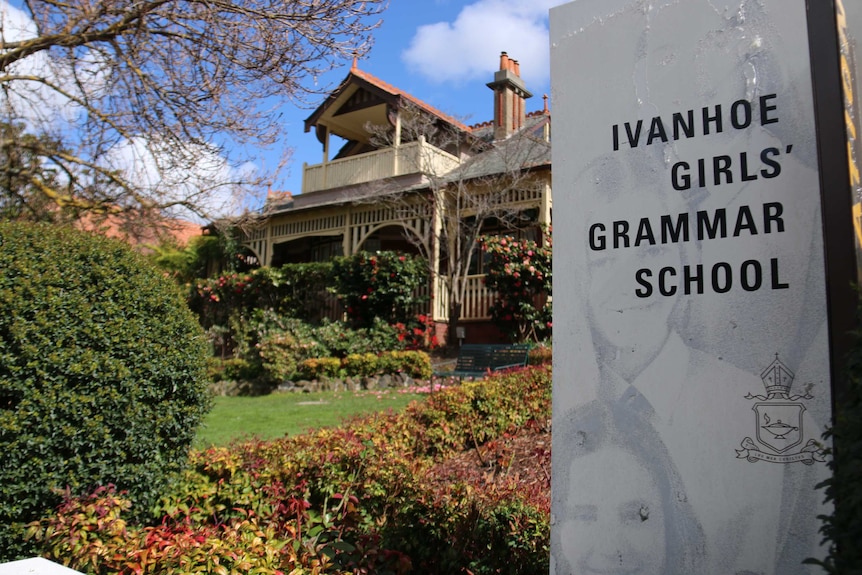 An image of the Ivanhoe Girls' Grammar School sign with school in background on a sunny day.