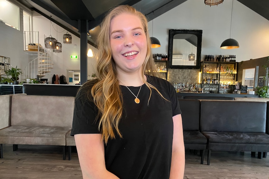 A woman smiling in a cafe.