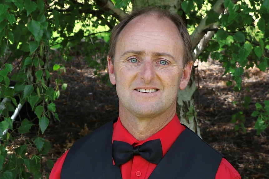 A man wearing a red shirt and bowtie
