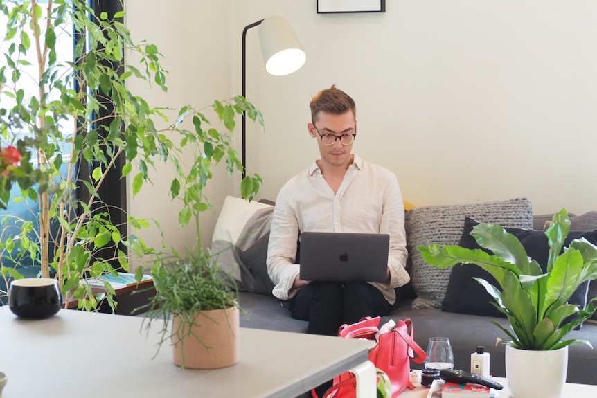 Glenn Turnham uses his laptop in his living room.