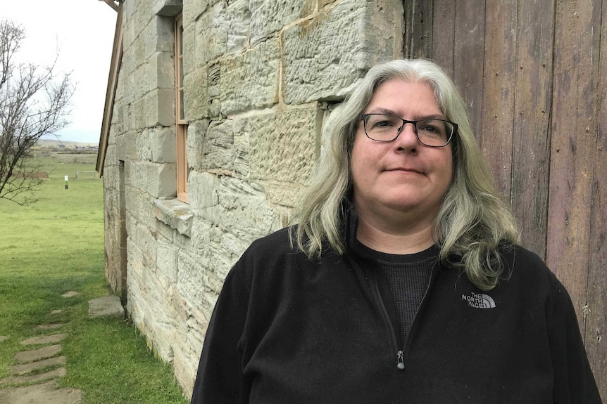 Archaeologist and professor Eleanor Casella leans against a convict-era building