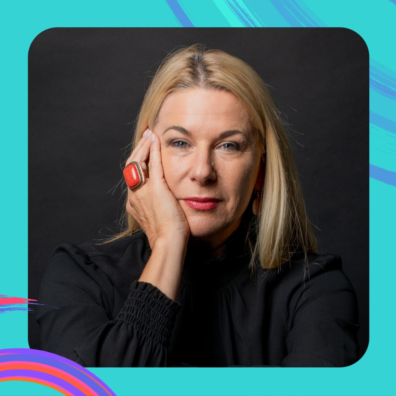 Mandy Nolan holds her chin in her right hand looking at the camera. She has a big red ring on her finger and long, blond hair.