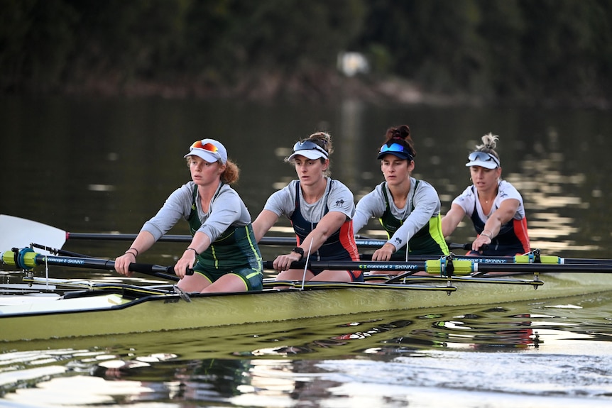 Four women rowing a boat in a river