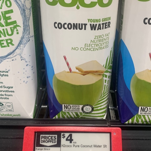 A coconut water product on the supermarket shelf at Woolworth with a "prices dropped" tag, priced at $4.