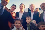 Asylum seekers pose with the Greek prime minister