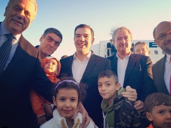 Asylum seekers pose with the Greek prime minister