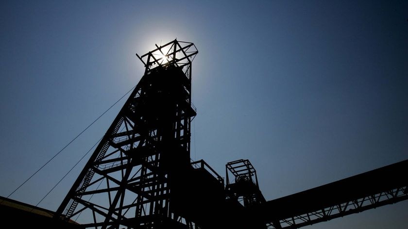 Sunlight shines from behind a gold mine pithead near Johannesburg.