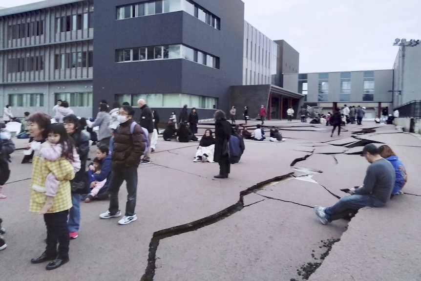 A blurry photo of cracks in the ground surrounded by people standing 
