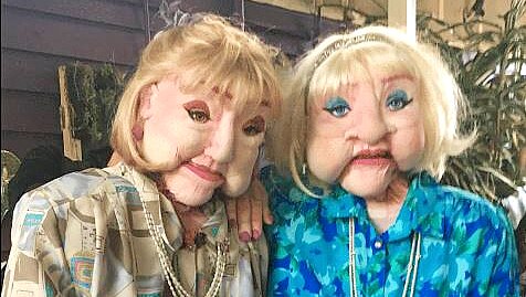 Two life-sized foam puppets of women in their 80s.