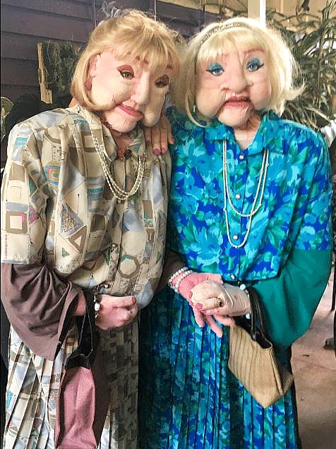 Two life-sized foam puppets of women in their 80s.