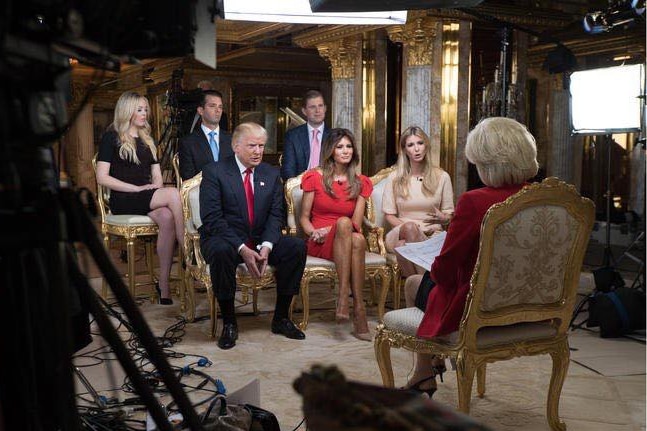 Trump and his family sit on a gilded couch.