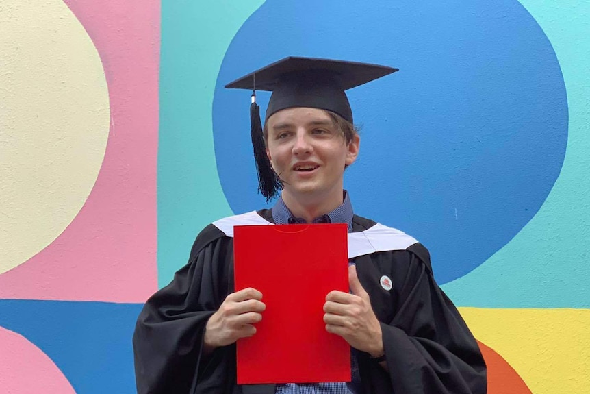 Portrait of Ty De Salis in graduation gowns at his university graduation.