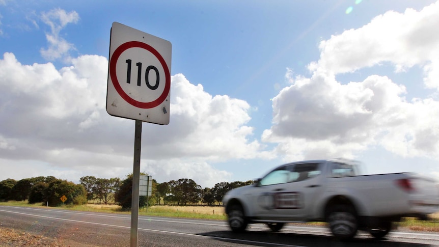 A four wheel drive ute speeds past a road speed sign which reads 110km/h
