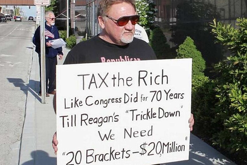 James Hodgkinson holds a sign during a protest.