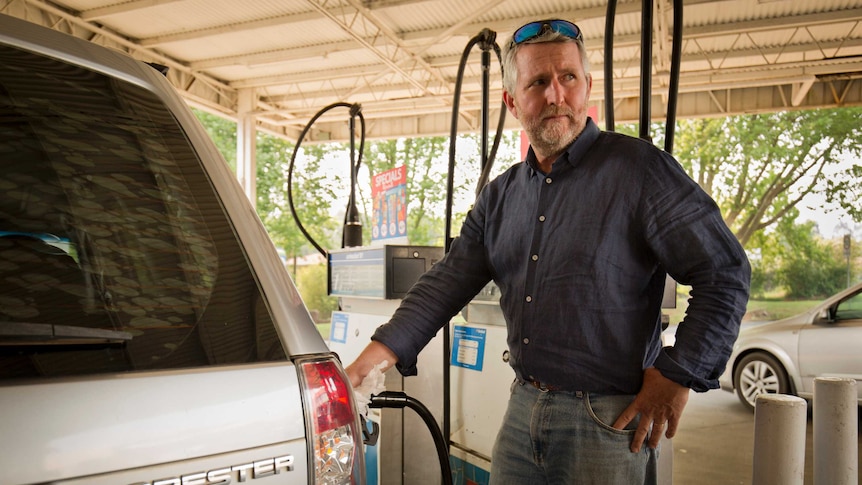 Peter Lynch stands at a fuel bowser filling up his Subaru Forester.