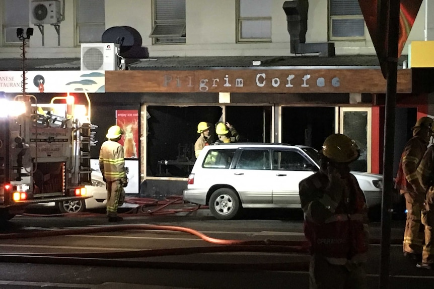 Firefighters outside the burnt-out Pilgrim Coffee.