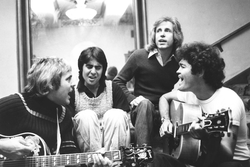 Black and white shot of Tommy Boyce, Davy Jones, Bobby Hart and Micky Dolenz of the band The Monkees rehearsing casually in 1975