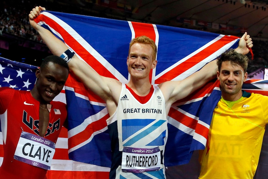 Britain's Greg Rutherford celebrates taking out the gold, flanked by bronze medallist Will Claye and silver medallist Mitchell Watt.