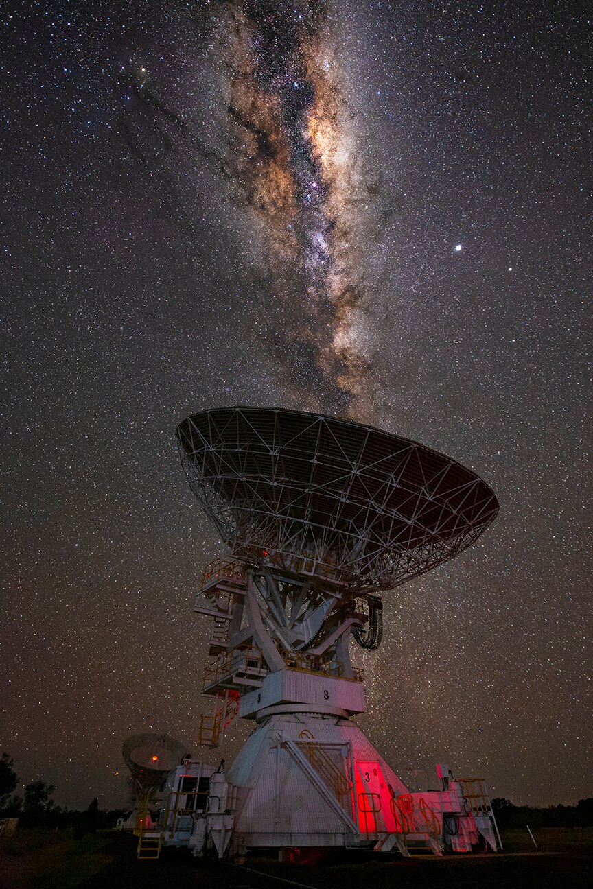The milky way behind a large radio telescope