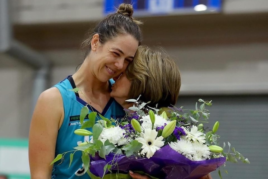 Jenna O'Hea hugs Southside Flyers WNBL team owner Val Ryan, who is handing her flowers.