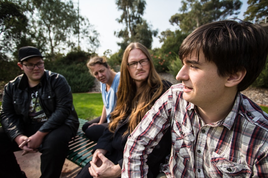 Bendigo university student Jack Surplice sits in the park with his friends.