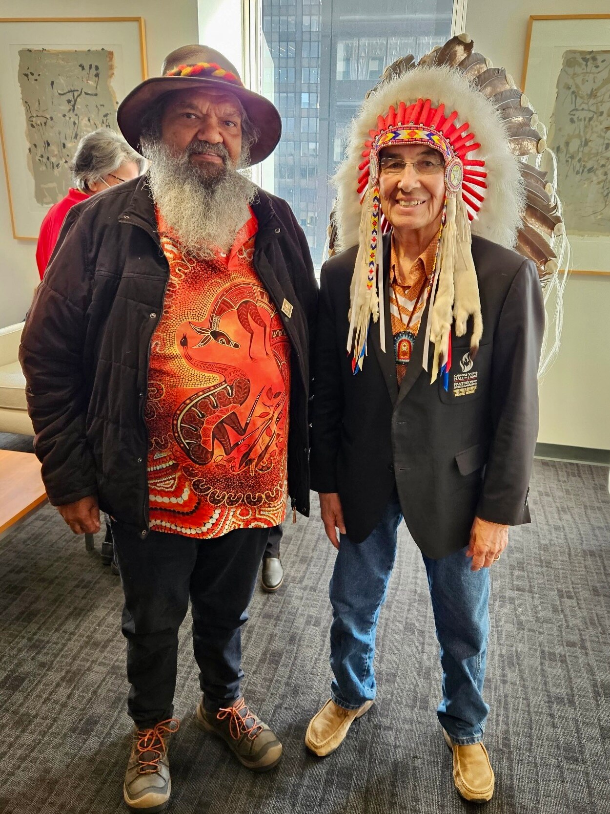 Aboriginal elder and native American leader with feathery headpiece standing together