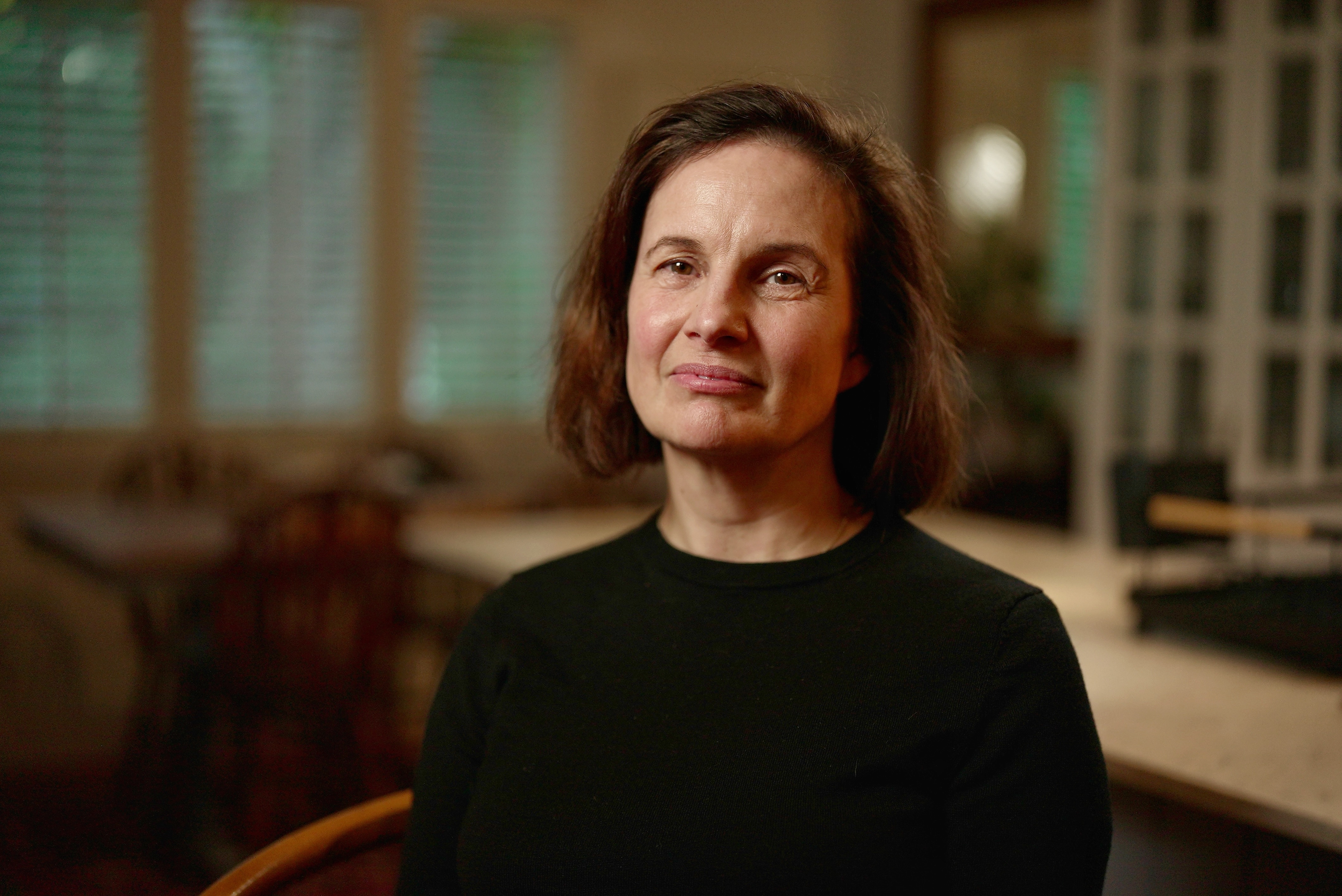 A mum wearing a black top looks into the camera.