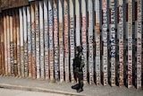 A Mexican National Guard Soldier stands guard at a section of the US-Mexico border wall