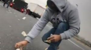 Driver collects money spilled on highway by an armoured truck in New Jersey.