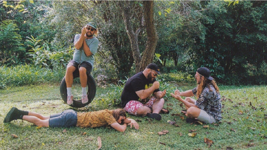 Beddy Rays members hanging out in a park, one member on a tyre swing