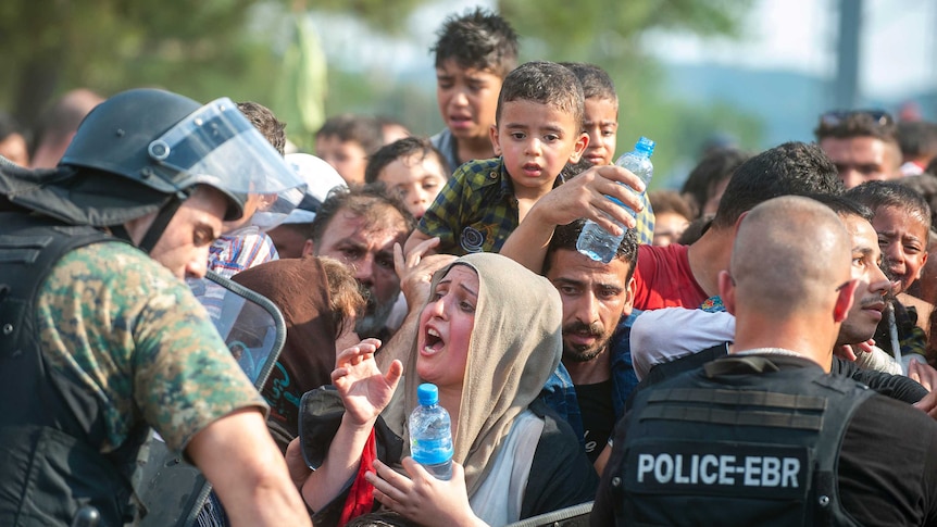 Police block a group of migrants trying to cross the Macedonian-Greek border
